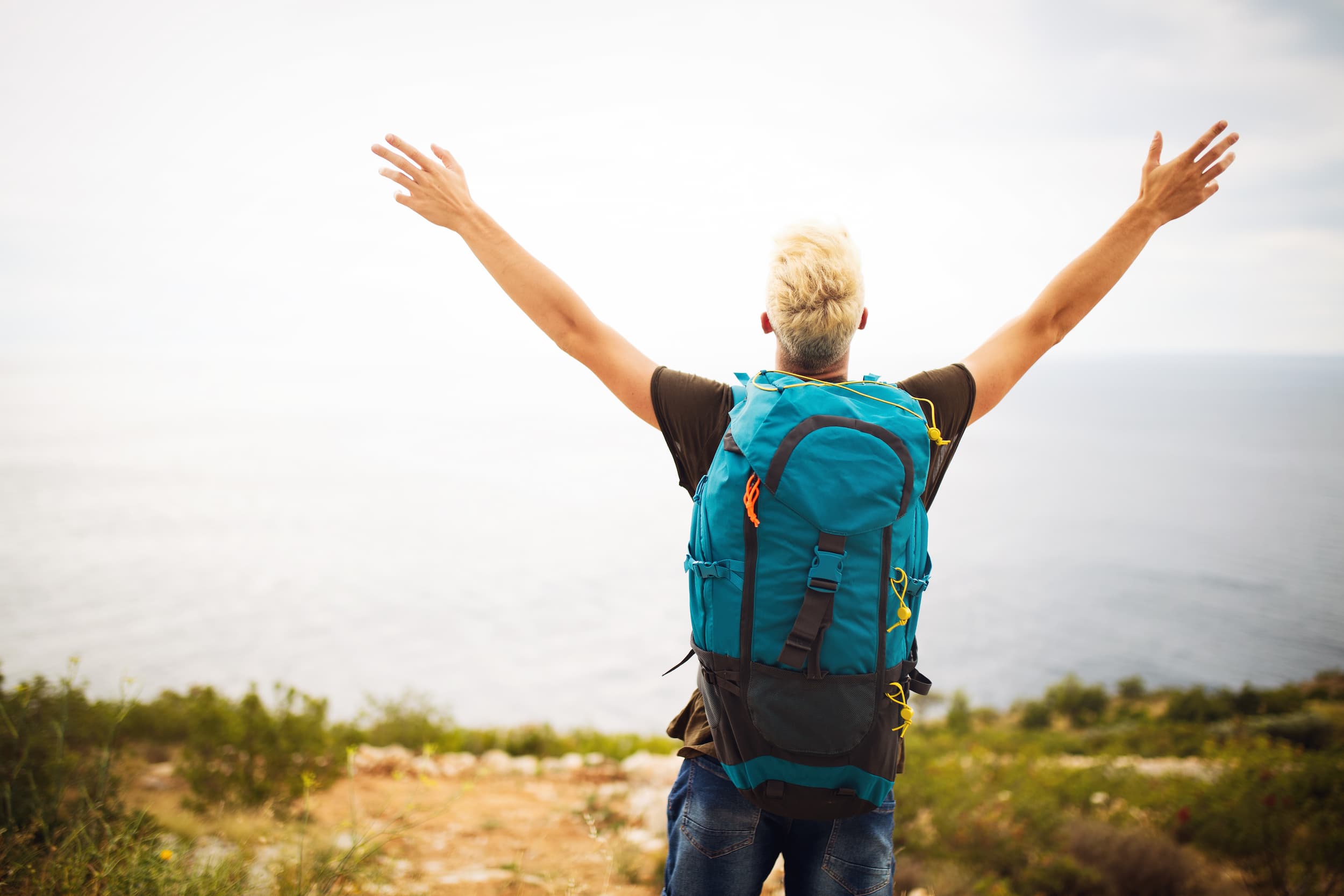 backpacker-reaches-top-of-hill-with-arms-raised-2026-01-08-22-30-49-utc (1)